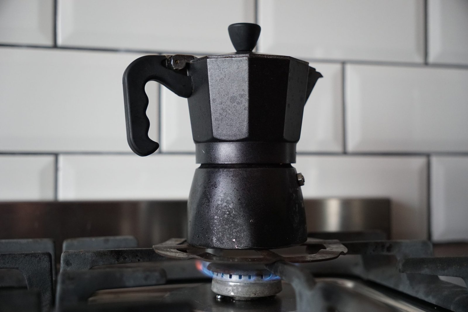 a black moka pot on a stove
